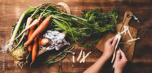 Cooking - chef's hands preparing fresh root vegetables in the kitchen photo