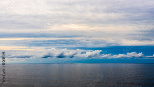 A ship floating on the beach with a blue sky in view.