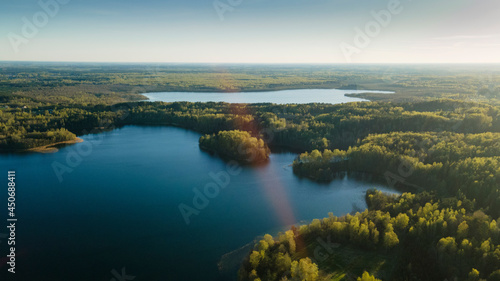 Aerial drone photo of green tree crones growing in lake shore. Nature landscape. Top view of a forest lake. Travel concept. © kalyanby