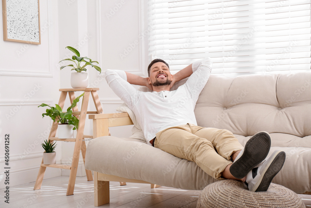 Handsome man relaxing on sofa at home Handsome man relaxing on sofa at home