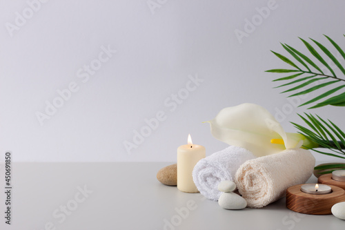 Spa treatment with candles  towel and flowers on white background. Close up  copy space