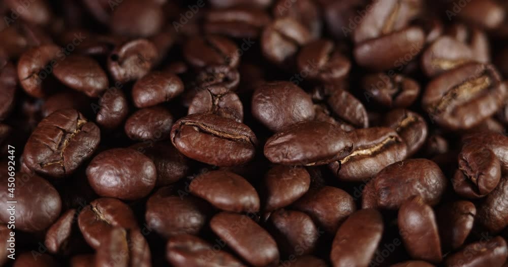 Roasted coffee beans dolly shot. Aromatic coffee beans move slowly. Slide slow motion close-up of whole roasted coffee beans. Roasted coffee beans dolly shot. Aromatic coffee beans move slowly. Slide slow motion close-up of whole roasted coffee beans.