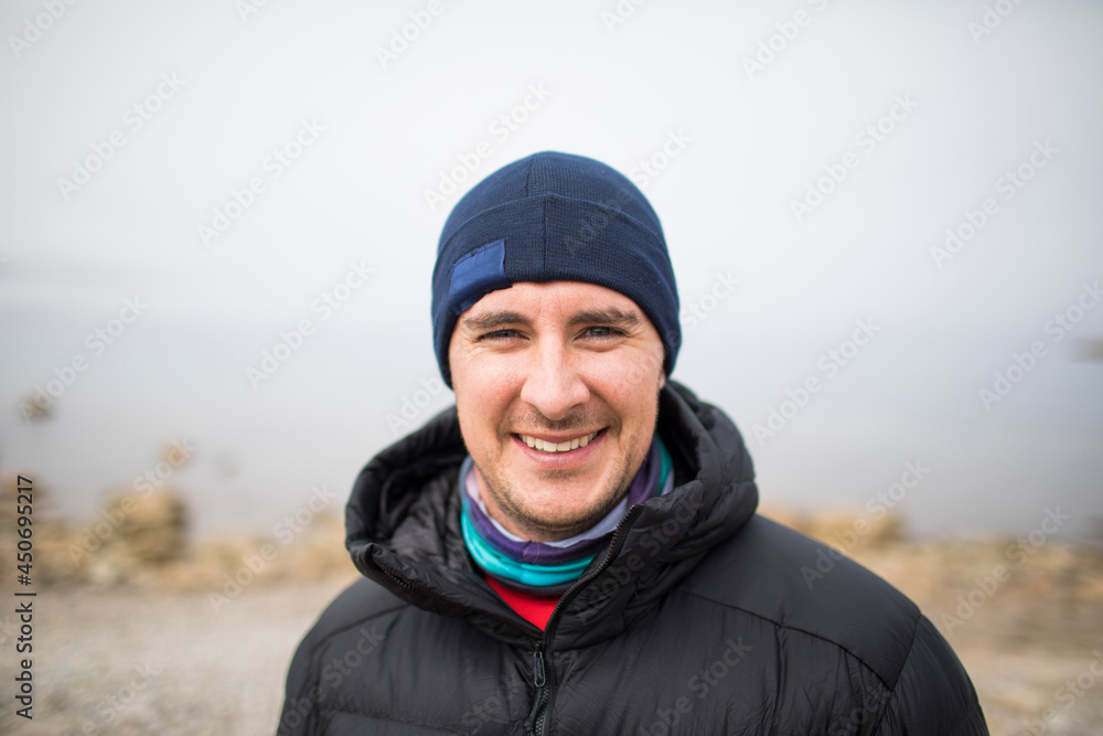 Portrait of man wearing warm clothes next to the ocean. Portrait of man wearing warm clothes next to the ocean.