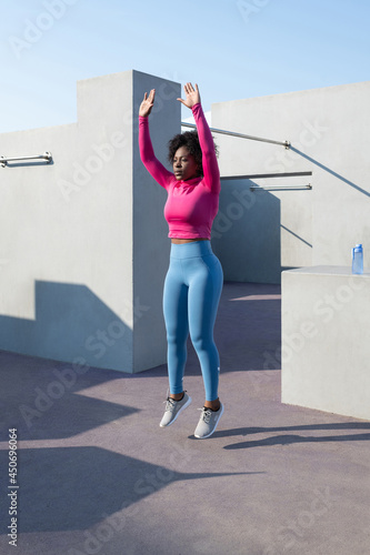 African American sportswoman doing burpee exercise photo