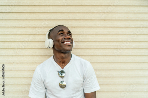 young african man listening to music through his headphones