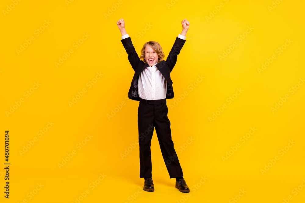 Full body photo of happy excited screaming boy raise hands in triumph pass exam isolated on yellow color background Full body photo of happy excited screaming boy raise hands in triumph pass exam isolated on yellow color background