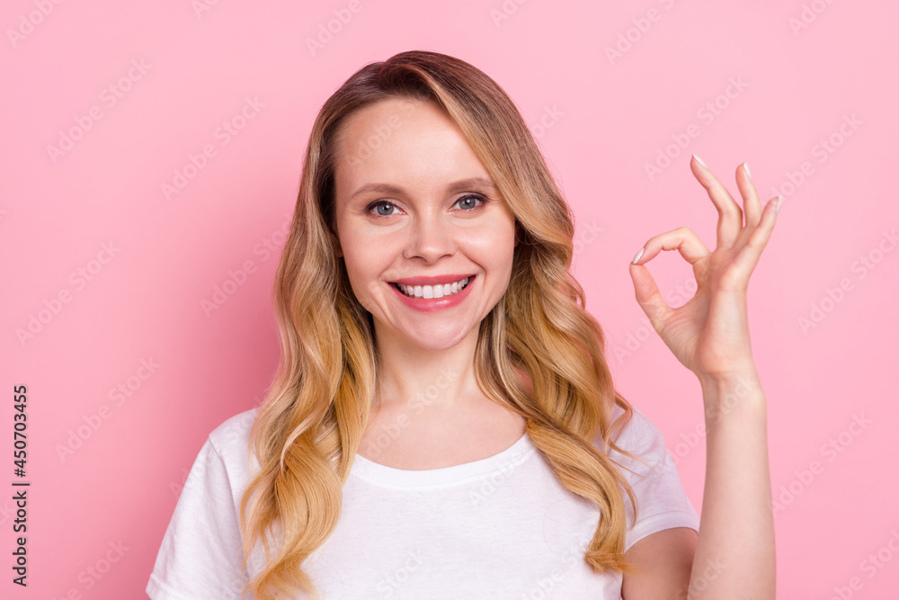 Photo of pretty young nice happy woman show hand okay sign smile recommend isolated on pink color background Photo of pretty young nice happy woman show hand okay sign smile recommend isolated on pink color background