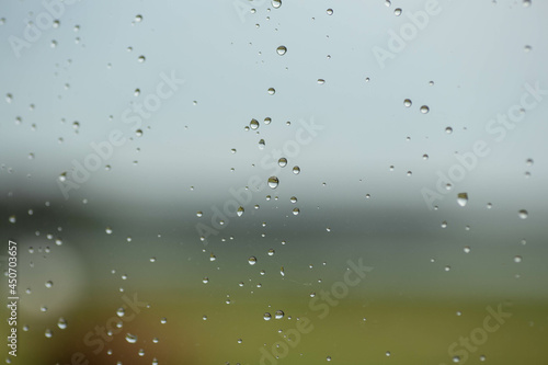 Raindrops on the glass at beautiful gentle nature gradient colors.