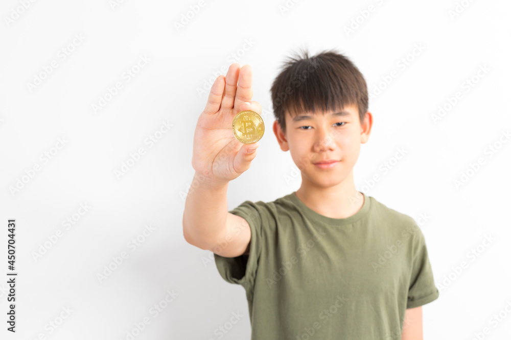 Asian boy holds a coin bitcoin on a white isolated background. Asian boy holds a coin bitcoin on a white isolated background.