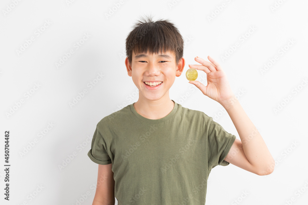 Asian boy holds a coin bitcoin on a white isolated background. Asian boy holds a coin bitcoin on a white isolated background.