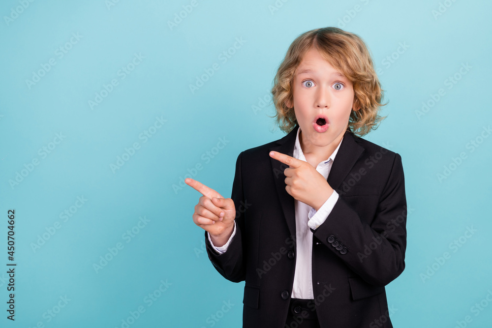 Photo of impressed little blond boy point empty space wear uniform isolated on blue color background Photo of impressed little blond boy point empty space wear uniform isolated on blue color background