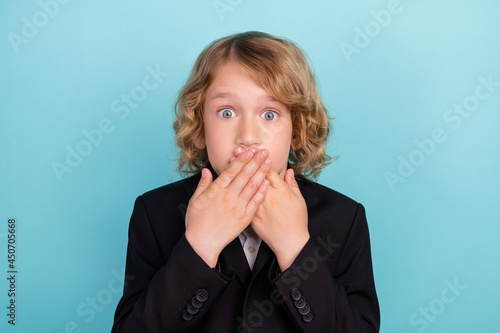 Photo of voiceless small blond boy close mouth wear uniform isolated on blue color background photo