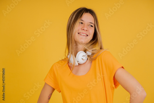 Young woman with headphones while standing against isolated background.