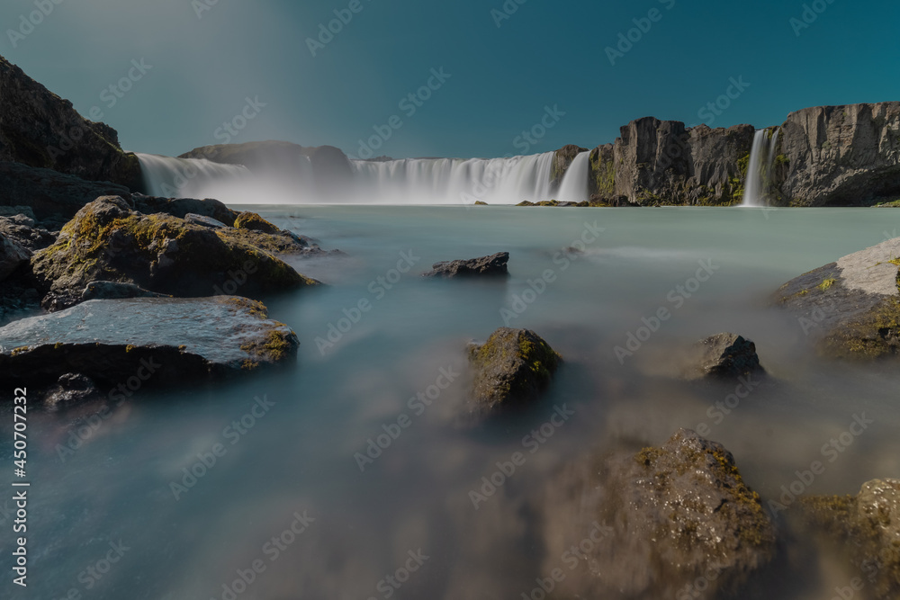 Long exposure photo of magnificent Godafoss waterfall in northern Iceland on a warm summer day. Visible flow of water coming from the waterfall.