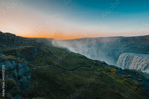 Beautiful Hafragilfoss waterfall in the Dettiffos area, large amount of water falling down making a droplet curtain during summer sunset in rich colors. Nice evening next to a big waterfall.