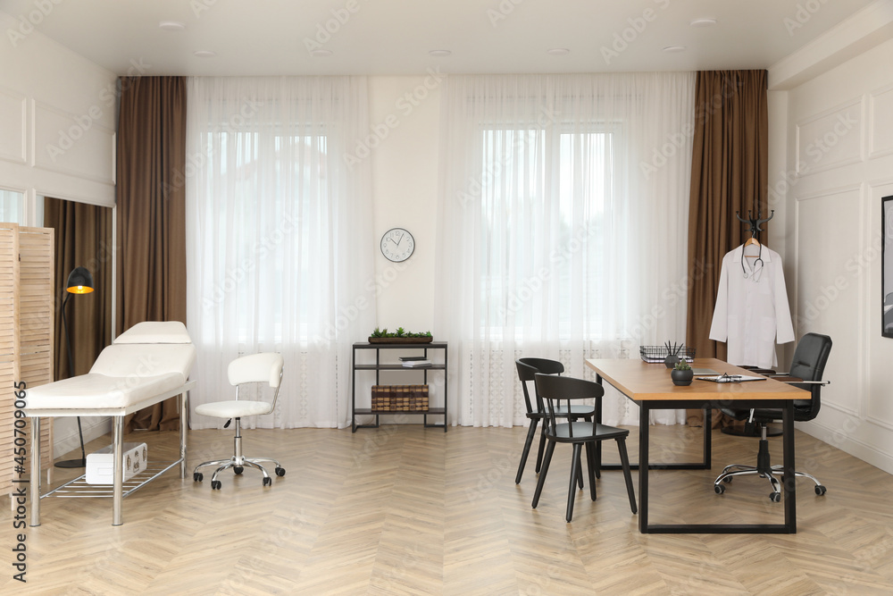 Modern medical office interior with doctor's workplace and examination table