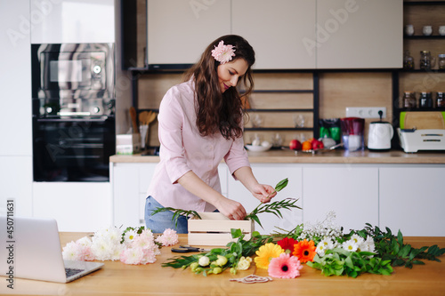 Young female florist record video tutorial of floral compositions design on camera  woman interior designer shoot vlog on camera  arrange handmade house flower decorations