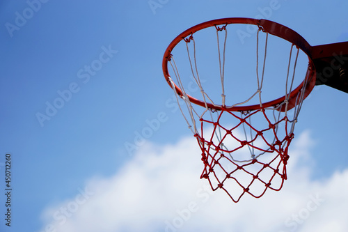 Bottom view of an empty basketball basket hoop against the blue sky. Concept : sport equipment. Favorite for Thai students or teenagers to play for competition, for fun or for good heath.  © Sanhanat