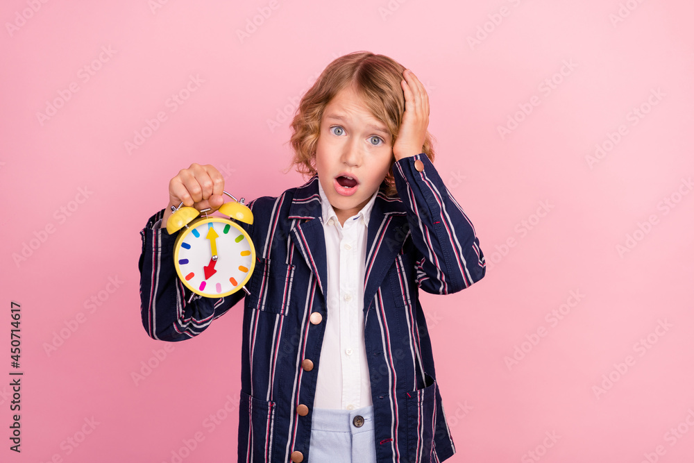 Photo of young school boy amazed shocked hand touch head oversleep late clock isolated over pink color background