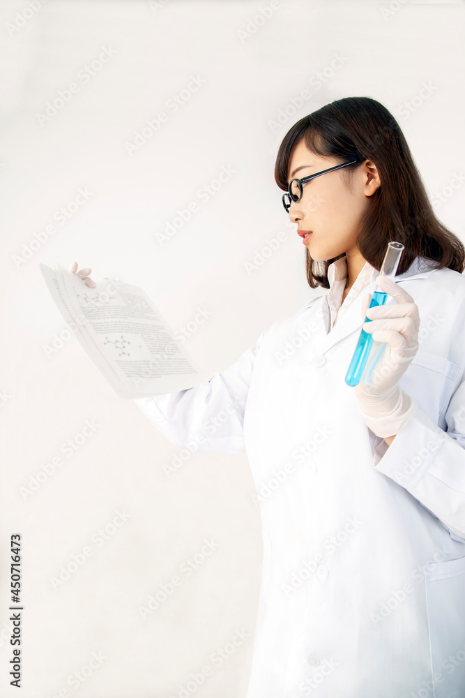 文献と試験管を持つ白衣を着た理系女子の立ち姿 文献と試験管を持つ白衣を着た理系女子の立ち姿