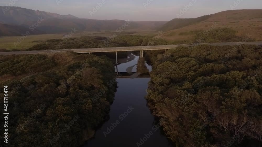 AERIAL - Centered bridge over calm river AERIAL - Centered bridge over calm river