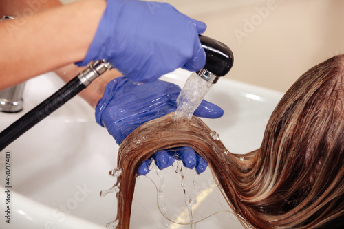 Hairdresser in beauty salon washes his client hair