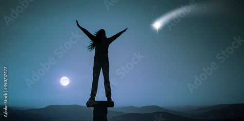 Frau mit ausgebreiteten Armen in einer Vollmondnacht