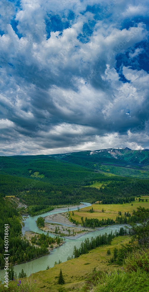 picturesque view of plain with lake near hills and mountains under white fluffy clouds in blue sky at sunny day