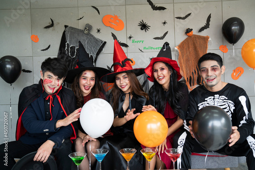 Young Asian people, a group of five people, in scary costumes. Group of friends wearing Halloween clothes preparing to join a party.