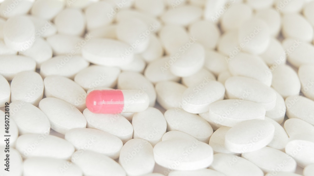 The doctor selected a bright pink and white capsule from all the white tablets and took it with his fingers without gloves. Pharmaceutical production. The person made a choice, treatment with capsules The doctor selected a bright pink and white capsule from all the white tablets and took it with his fingers without gloves. Pharmaceutical production. The person made a choice, treatment with capsules