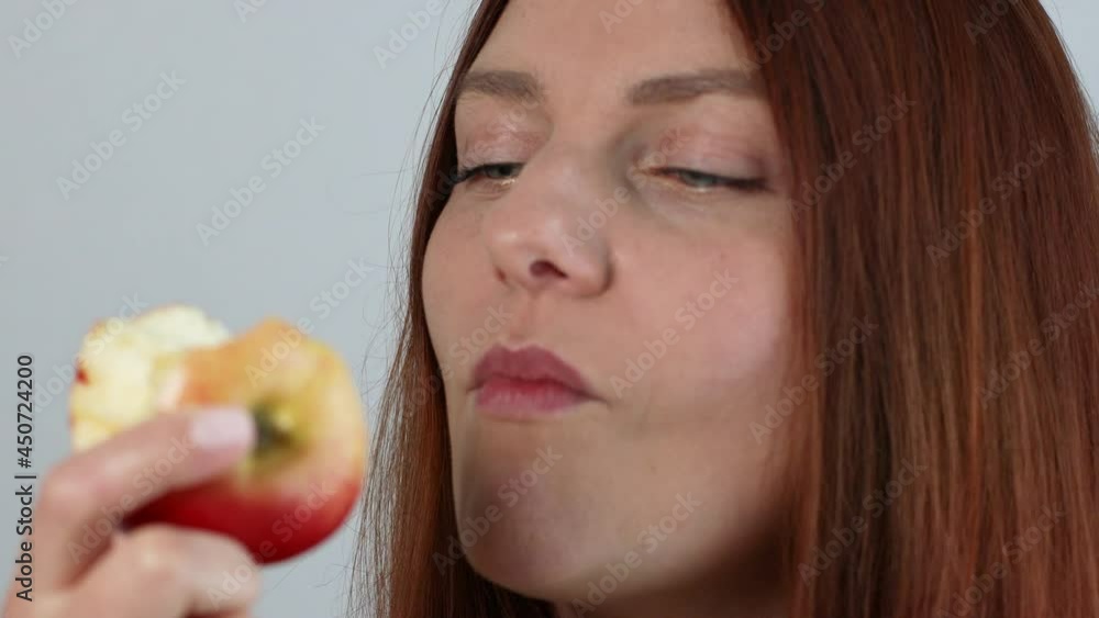 Young caucasian woman eating ripe red apple with closed eyes, enjoying fresh organic snack, healthy eating and lifestyle concept Young caucasian woman eating ripe red apple with closed eyes, enjoying fresh organic snack, healthy eating and lifestyle concept