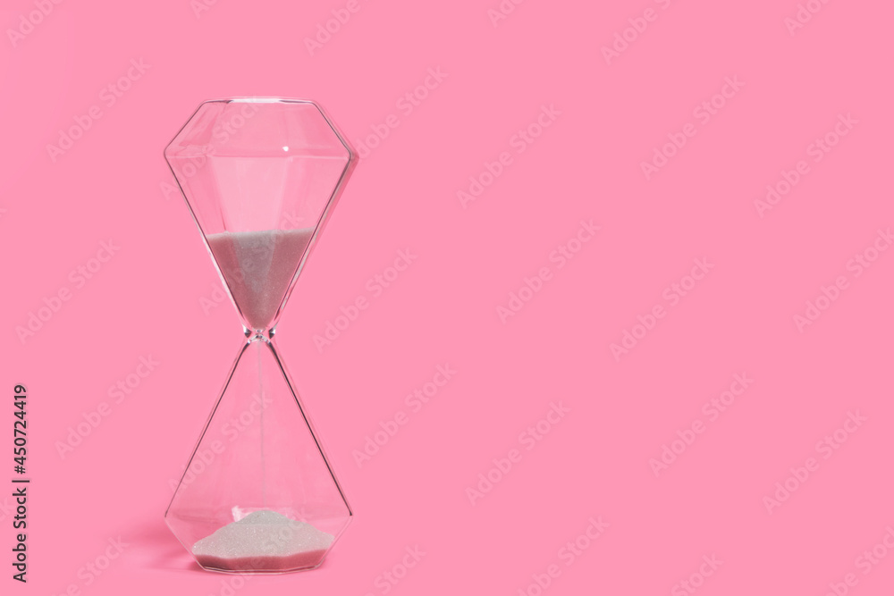 Hourglass on a pink background, passing time. Hourglass on a pink background, passing time.