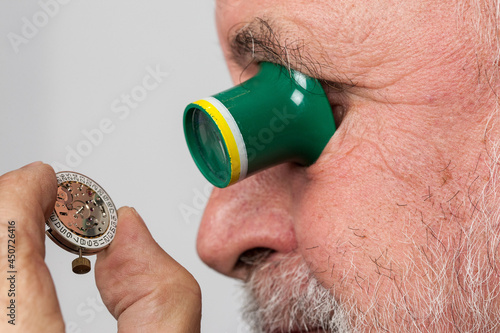 Billede på lærred Through his magnifying glass an older, experienced watchmaker looks at a small clockwork