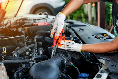 The mechanic uses pliers to check the condition of the car and fix the car.