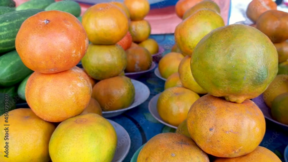 Pile stacks of freshly picked oranges at the local fruit and vegetable market on tropical island Timor Leste, South East Asia Pile stacks of freshly picked oranges at the local fruit and vegetable market on tropical island Timor Leste, South East Asia