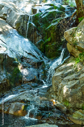 Cascada entre rocas con musgo verde