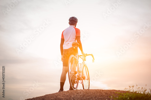 Wallpaper Mural A man ride on bike on the road. Man riding vintage sports bike for evening exercise. A man ride bicycle to breathe in the fresh air in midst of nature, meadow, forest, with evening sun shining through Torontodigital.ca