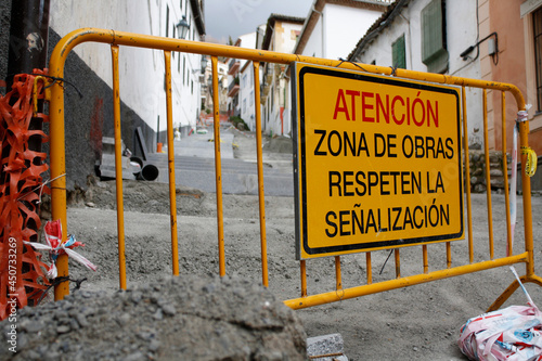 Yellow fence of works. On a street in the Realejo neighborhood. Old area of ​​Granada.