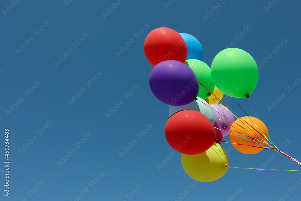Bunch of colorful balloons against blue sky. Space for text