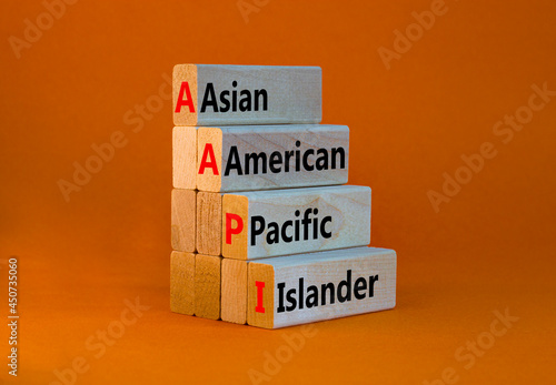 AAPI symbol. Abbreviation AAPI asian american pacific islander on wooden blocks. Beautiful orange background. Copy space. Business and AAPI asian american pacific islander concept. photo