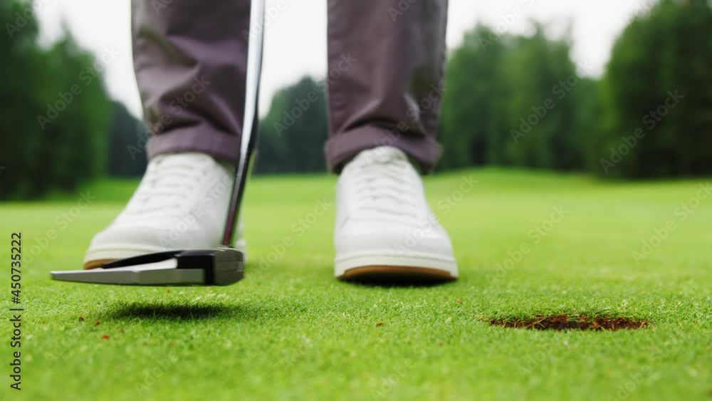 Man hammering the ball into the hole on the golf course