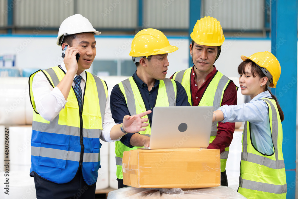 factory workers meeting and using laptop computer for work in warehouse storage factory workers meeting and using laptop computer for work in warehouse storage