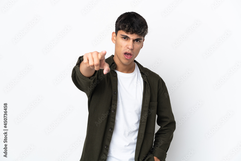 Young man over isolated white background frustrated and pointing to the front Young man over isolated white background frustrated and pointing to the front