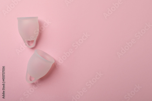 White menstrual cups on pink background, flat lay. Space for text
