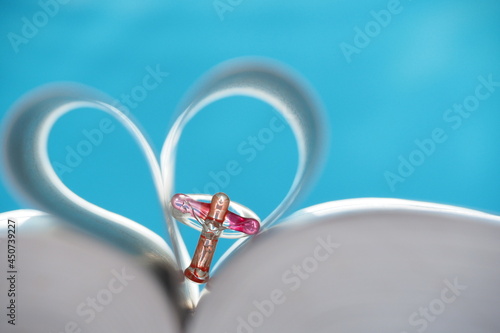 Fototapeta Naklejka Na Ścianę i Meble -  Close up glass crucifix in Blurred heart shape bible page on blue background. Concept hope, faith, love, symbol christianity, religious Christian image, study church online, Jesus loves you, Easter.