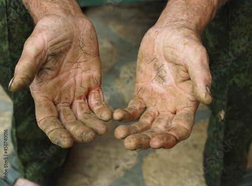 The hands of a senior handyman man, with calluses and cracks. Agricultural manual labor. photo