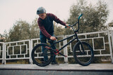 Professional young sportsman cyclist with bmx bike at skatepark