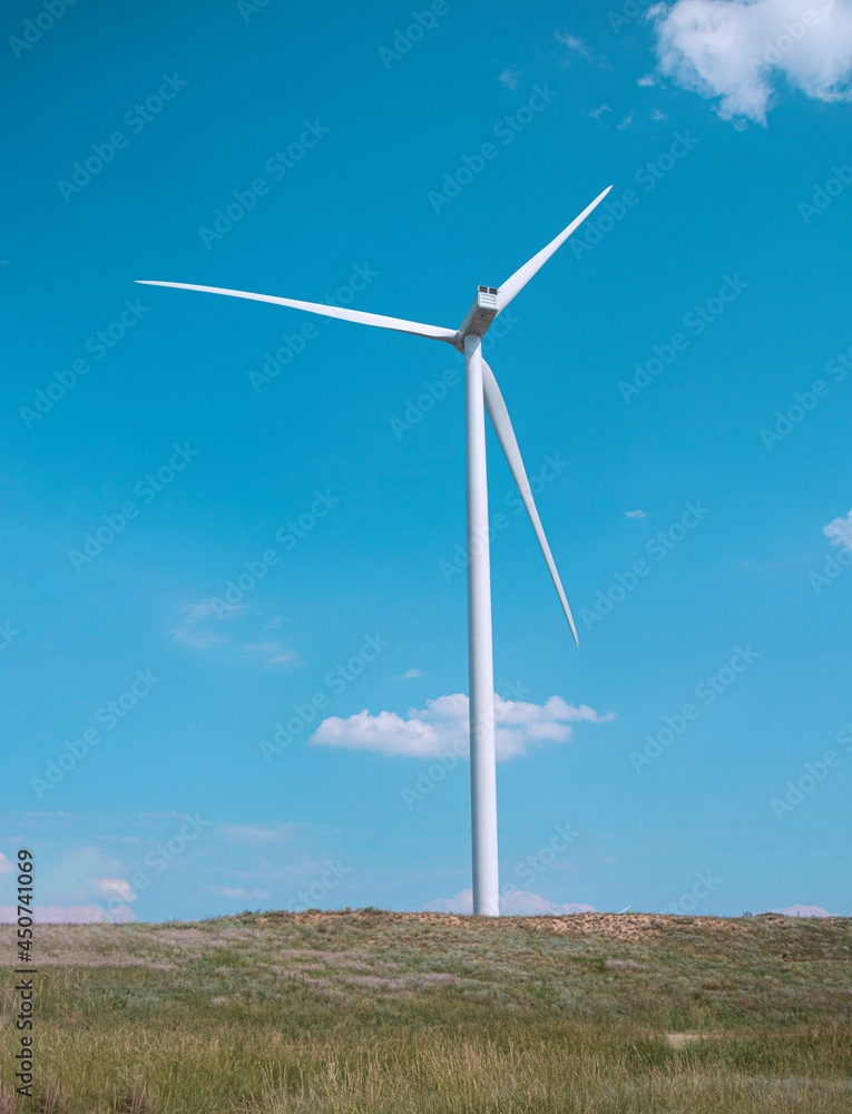 windmill on the background of the cloudy blue sky. Concept of alternative energy production from wind. Modern windmill with full-length blades. High quality photo windmill on the background of the cloudy blue sky. Concept of alternative energy production from wind. Modern windmill with full-length blades. High quality photo