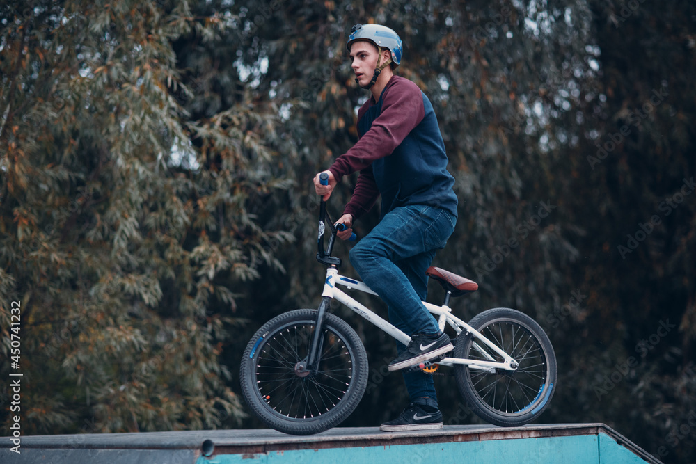 Professional young sportsman cyclist with bmx bike at skatepark