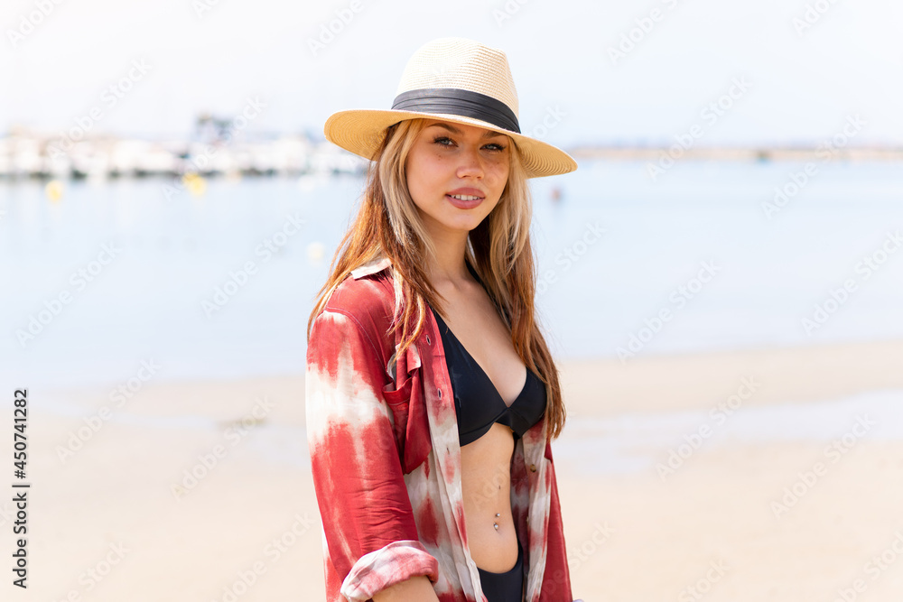 Young pretty blonde girl on the beach in summer holidays